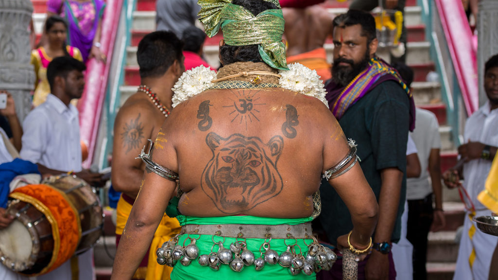 A Hindu man wears arm cuffs that cut into his flesh.