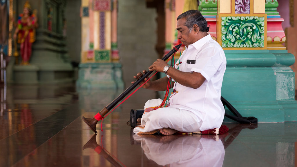 A musician plays in a Hindu temple. 
