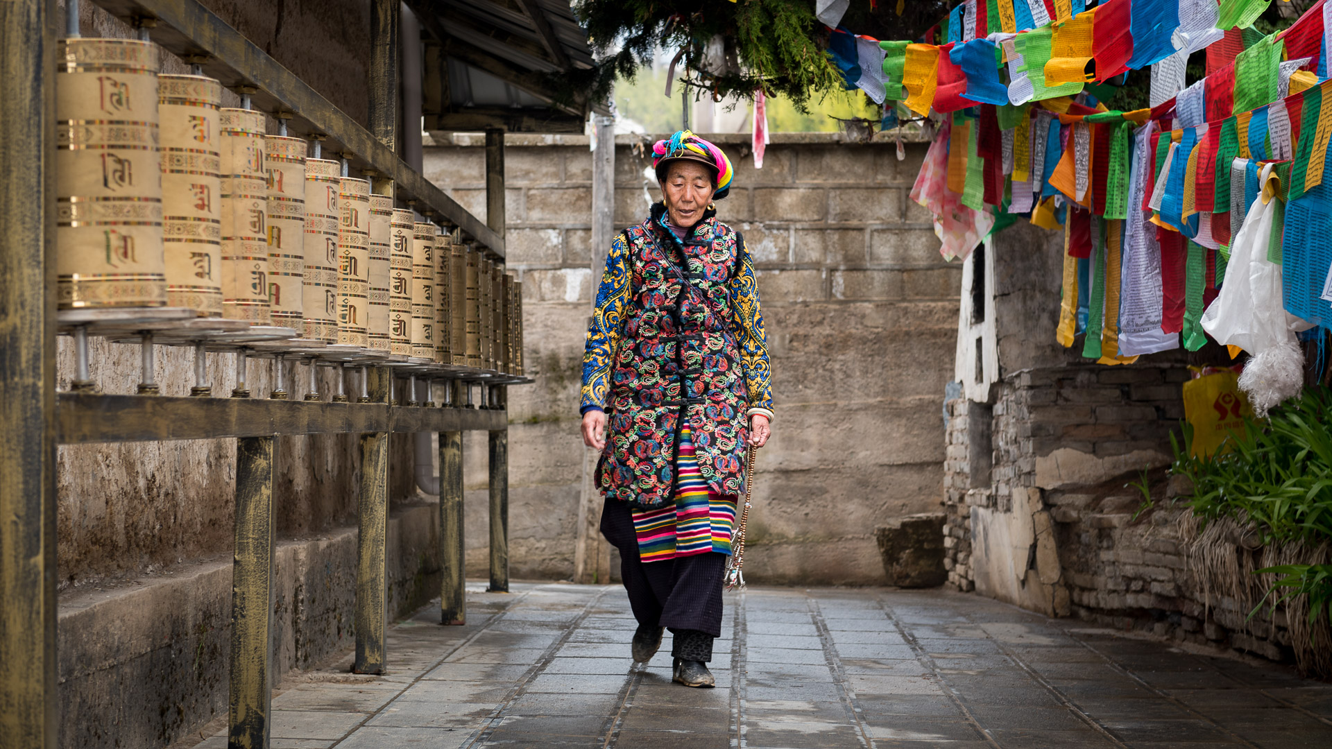 Tibetan woman circles a Buddhist temple in her daily prayer walk.