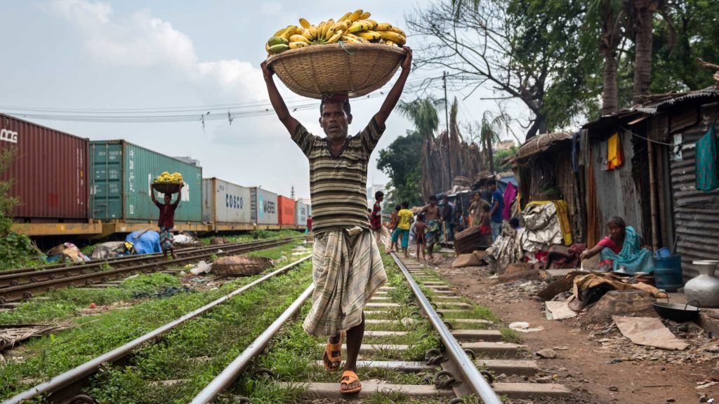 Men sell bananas along the railroad tracks in Dhaka. 