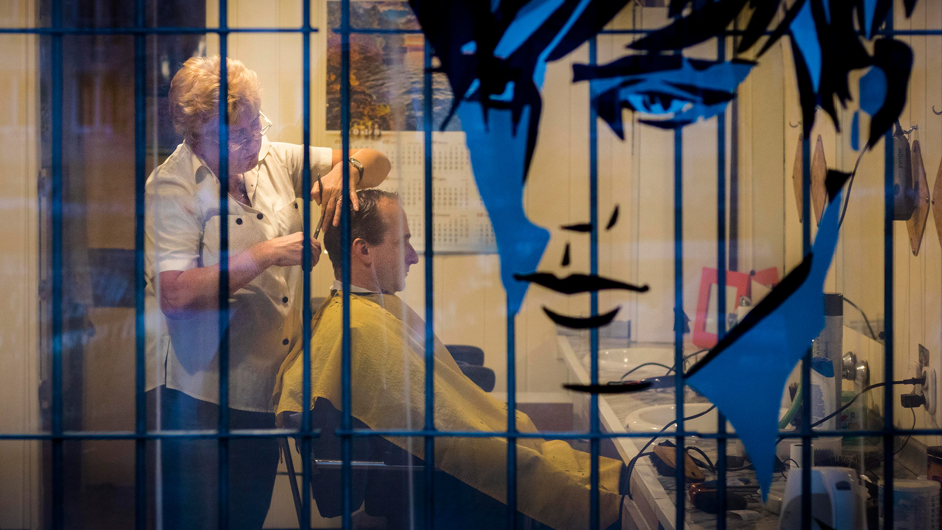 A Polish barber cuts customer's hair in Kraków, Poland. 