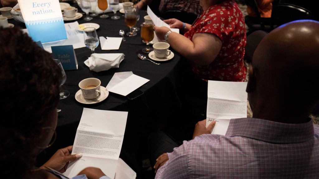 Dinner guests read letters from missionaries