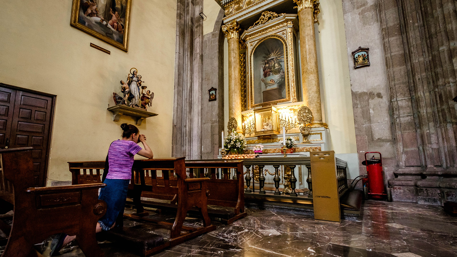 A woman prays in a Catholic cathedral in Mexico City. 