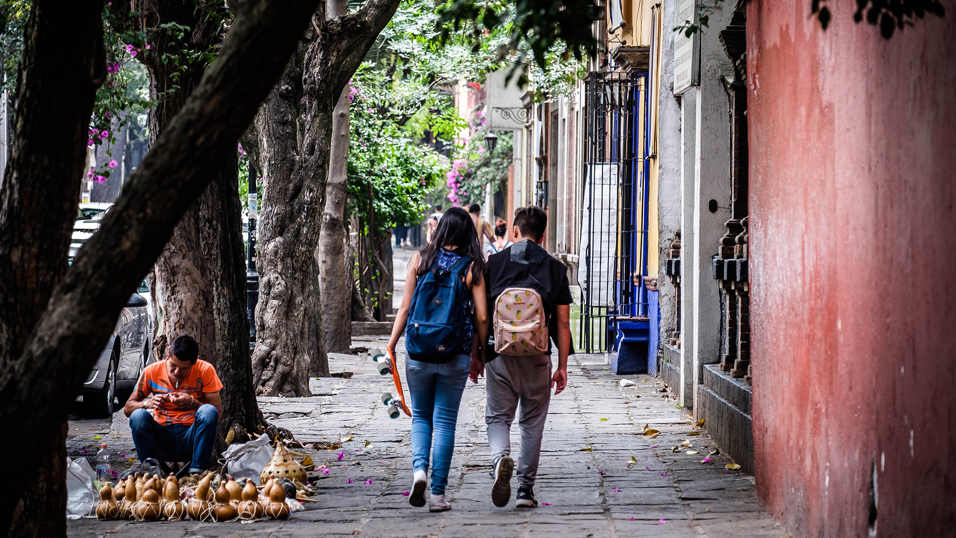 A couple walks down a street in Mexico City.