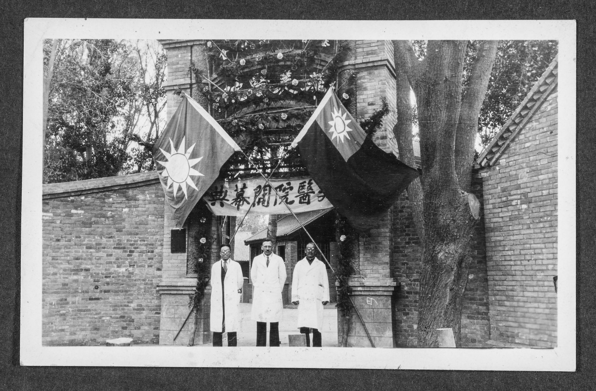 Dr. S.E. Ayers and two Chinese doctors stand at the gate of Chengchow Hospital on its opening day in 1936.