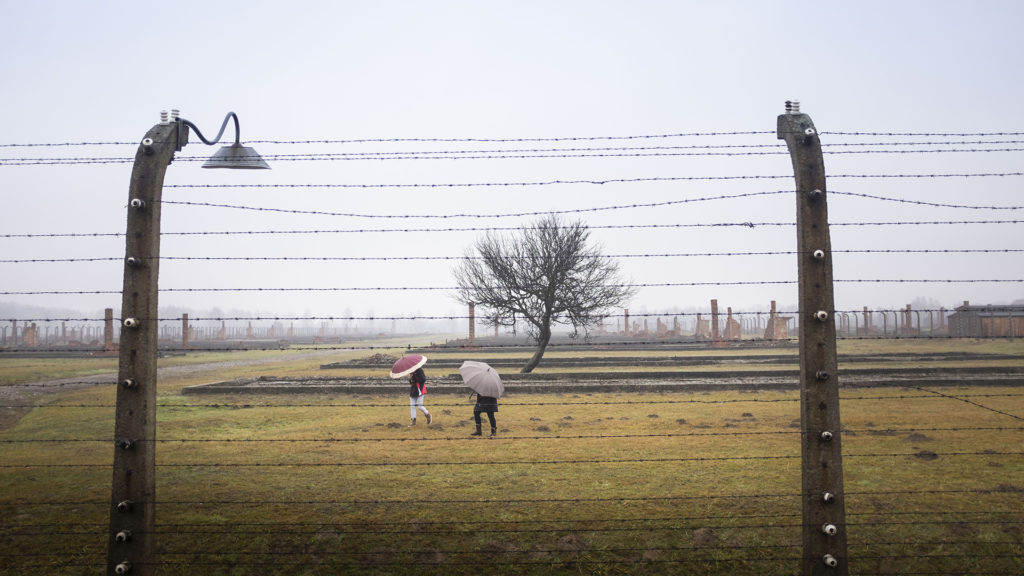 Winter scenes at the Auschwitz-Birkenau concentration camp near Kraków, Poland, are never cheerful and the weather usually has a big part to play. Even the cheerfully colored umbrellas of tourists exploring the ruins of the old camp barracks cannot change what history wrote there—the scar of concrete fenceposts and lives lost remain.