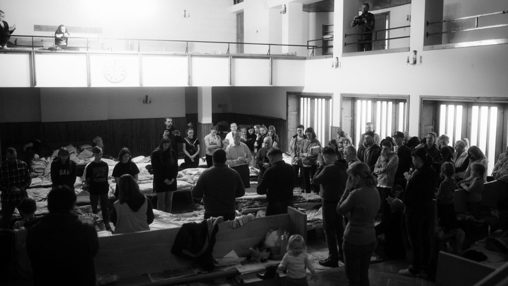 Members of Chelm Baptist Church pray in their sanctuary that has now become a safe haven for refugees. Photo by Martin Linza