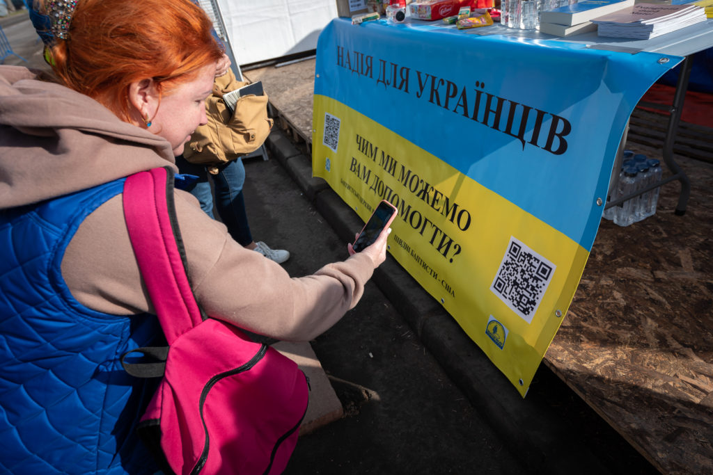 Oksana scans the Hope for Ukraine QR code at the station established by Romanian Baptists and now manned by a Southern Baptist Disaster Relief Team station on the border of Ukraine and Moldova. The website provides the opportunities to talk directly with Ukrainian and Russian-speaking Christians. IMB Photo 