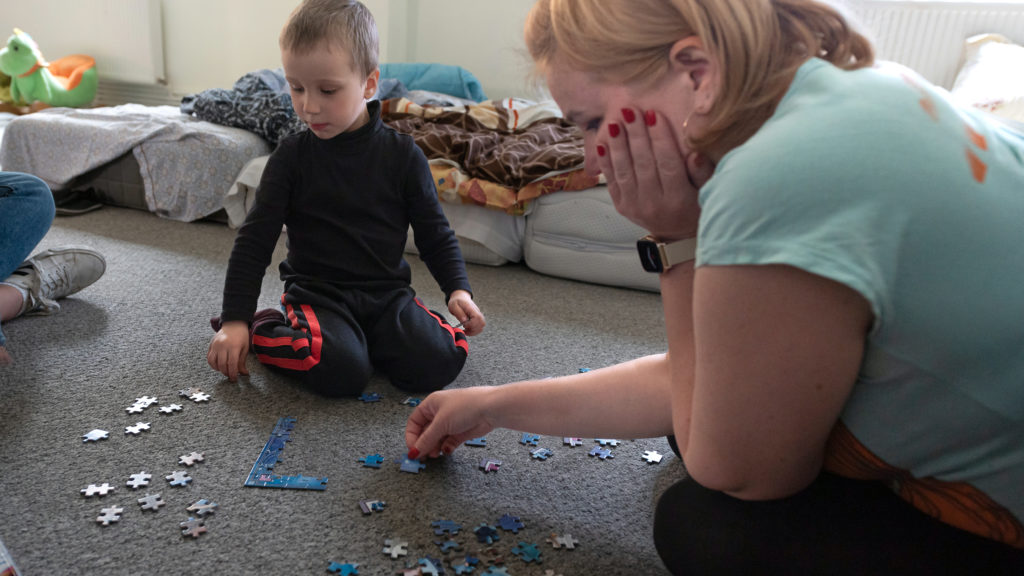 Den and his mother, Victoria, work on completing a puzzle. They are waiting to hear whether they can travel to seek asylum in Australia. IMB Photo