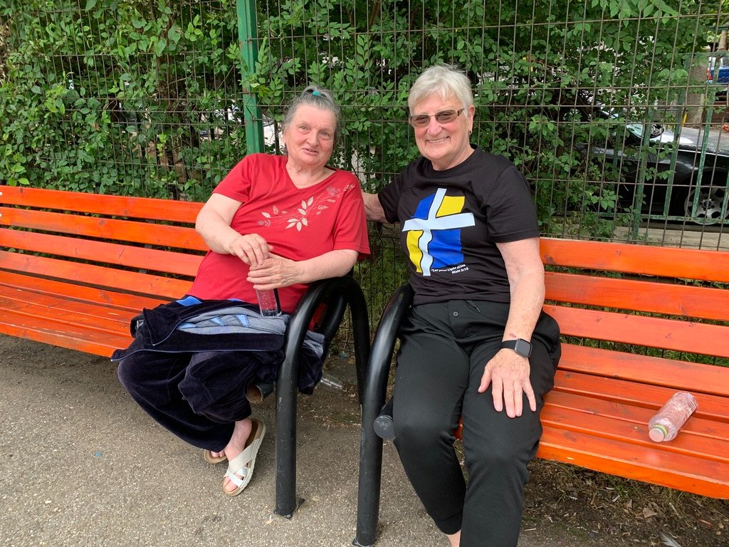 Linda Gray, right, and Ludmila visit on a park bench on the campus of a school that houses refugees. Ludmila is a Christian and shared her testimony with Gray. IMB Photo